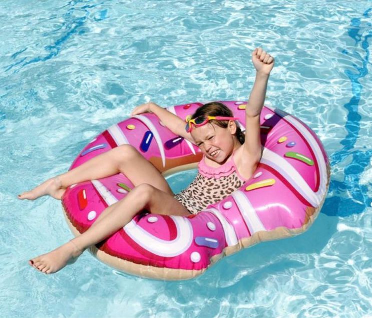Little girl in the lido, in a pink doughnut inflatable. Photo by Simon Pizzey, Stroud News and Journal.